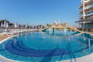 a large swimming pool next to a hotel at Aparthotel Costa Calma in Aheloy