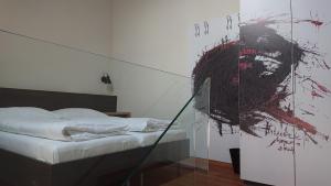 a bedroom with a bed with a painting on the wall at Maison am Liesingbach in Vienna