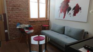 a living room with a couch and a brick wall at Maison am Liesingbach in Vienna