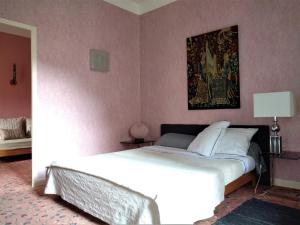 1 dormitorio con 1 cama y una pintura en la pared en Ermitage de Peyreleau, en Peyreleau