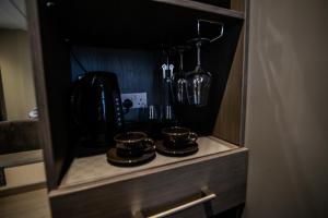 einen Schrank mit drei Kaffeetassen und einem Mixer in der Unterkunft Ladywell House Suites - Chinatown - Self Check-in in Birmingham