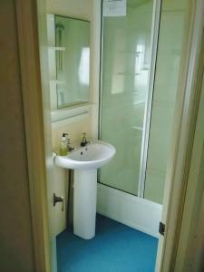 a bathroom with a white sink and a shower at Caravan hire Winthorpe Skegness in Skegness