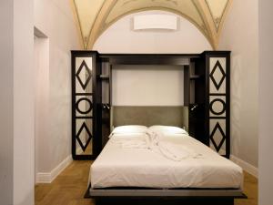 een slaapkamer met een bed met een zwart-wit hoofdeinde bij Vivaldi luxury suites in Florence