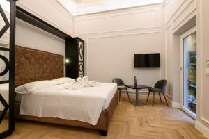 a bedroom with a bed and a table and a tv at Vivaldi luxury suites in Florence