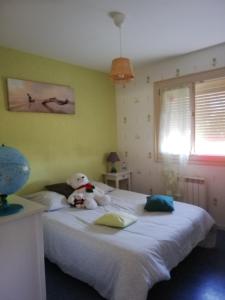 a bedroom with a bed with two stuffed animals on it at Chambre privée calme,campagne, piscine,étape,déplacement pro,abri moto vélo,parking in Vaux-sur-Vienne