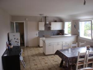 eine Küche mit einem Tisch und einem Kühlschrank in der Unterkunft 20 Résidence de Kerlosquen in Fouesnant