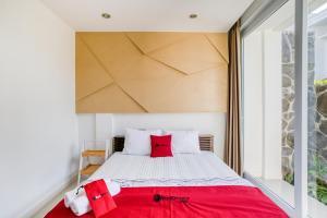 a bedroom with a large bed with red pillows at RedDoorz near Universitas Islam Indonesia in Yogyakarta