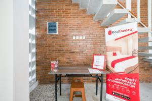 a bed room with a table in front of a brick wall at RedDoorz near Universitas Islam Indonesia in Yogyakarta