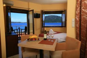 - une salle à manger avec une table et un bol de nourriture et de verres à vin dans l'établissement Faros Luxury Suites, à Marathopolis