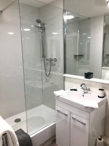 a white bathroom with a shower and a sink at The Red Lion Hotel in Oakford