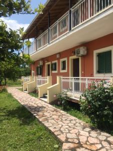 una vista laterale di un edificio con un sentiero di Nikos Apartments a Sidari