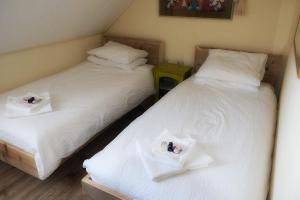 duas camas num quarto com lençóis brancos em B&B Madame em Lobith