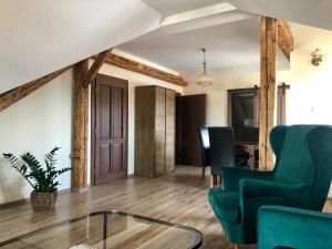 a living room with a green chair and a table at VILLA ANGEL in Rožňava