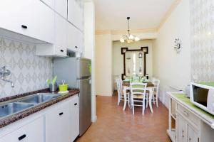 una cucina con armadi bianchi e tavolo con sedie di Appartaments Marrucini a Roma
