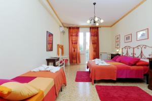 1 dormitorio con 2 camas con sábanas de color rojo y naranja en Appartaments Marrucini, en Roma