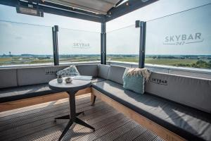 a bench in a room with a table and windows at Corendon Urban Amsterdam Schiphol Airport Hotel in Badhoevedorp