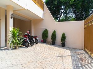 RedDoorz near Cipinang Indah Mall في جاكرتا: دراجة نارية متوقفة خارج منزل به نباتات