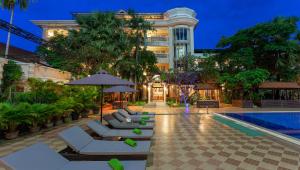 un hotel con tumbonas y una piscina en Somadevi Angkor Premium, en Siem Reap