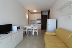 a kitchen and living room with a couch and a refrigerator at FLATS SOLARIUM in Bibione