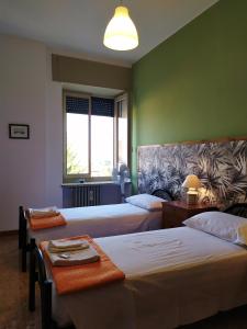 a hotel room with two beds and a couch at Ostello delle cartiere in Toscolano Maderno