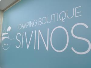 a sign that says anything boutique skiing on a blue wall at Sivinos Camping Boutique in Manerba del Garda