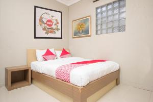 een slaapkamer met een bed met rode en witte kussens bij Super OYO Collection O 1061 Aliya Homestay in Yogyakarta