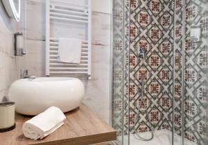 Un baño con lavabo blanco y ducha. en Calenda Suite, en Nápoles