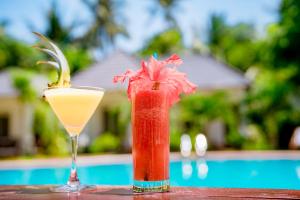 deux cocktails assis sur une table à côté d'une piscine dans l'établissement Long Mountain Resort, à Duong Dong