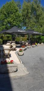 a group of tables and chairs with umbrellas at Hôtel Jeanne D'Arc in Saint-Chély-dʼApcher