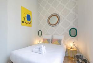 a bedroom with a white bed and a mirror at Apartments WS Opéra - Vendôme in Paris