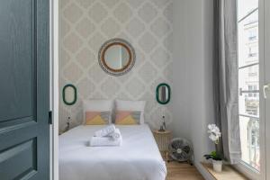 een slaapkamer met een wit bed en een spiegel bij Apartments WS Opéra - Vendôme in Parijs