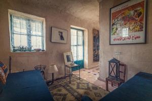 una sala de estar con 2 ventanas y un cuadro en la pared en Beit Al Fannan en Ţabaqat Faḩl