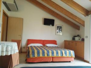 a bedroom with a bed and a tv on the wall at Hotel Venezia e la Villetta in Lido di Jesolo