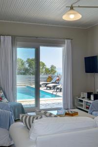 uma sala de estar com um sofá e vista para uma piscina em Lioniskari em Porto Ozias