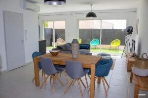 een woonkamer met een houten tafel en stoelen bij BASTIDE 9 in La Fare-les-Oliviers