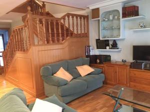 a living room with a couch and a staircase at VIVIENDA DE USO TURÍSTICO CENTRO in Avila
