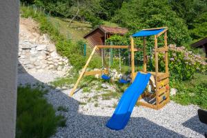 a playground with a blue slide in a yard at Nature View House with Sauna in Tolmin