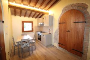 a kitchen with a table and a wooden door at Agriturismo la Tana in Città di Castello