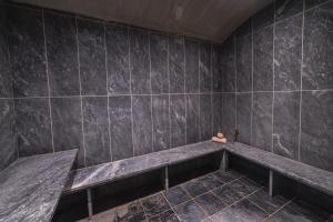 a black tiled bathroom with a bench in it at Horizon Blu Boutique Hotel in Kalamata
