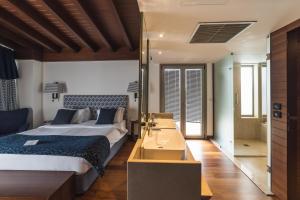 a bedroom with a large bed and a bathroom at Horizon Blu Boutique Hotel in Kalamata