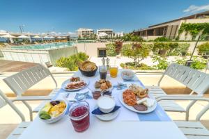 a white table with breakfast food on a balcony at Horizon Blu Boutique Hotel in Kalamata