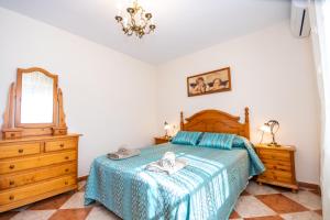 a bedroom with a bed and a dresser and a mirror at Cubo's Finca el Cortijito de Herrera in Alhaurín el Grande +43 photos