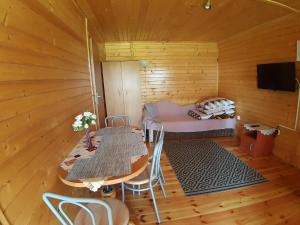 a room with a table and a bed in a cabin at Domek Irenka in Puck