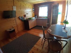 a dining room with a table and a kitchen at Domek Irenka in Puck