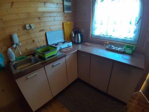 a kitchen with a stove and a sink and a window at Domek Irenka in Puck +6 photos
