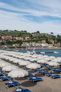 a bunch of chairs and umbrellas on a beach at Grand Hotel Portovenere in Portovenere