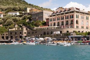 a group of boats in the water in front of a building at Grand Hotel Portovenere in Portovenere
