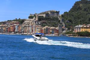 a boat on the water in front of a city at Grand Hotel Portovenere in Portovenere