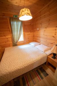 a bedroom with a bed in a wooden room at Holiday Village Kukkapää in Sulkava