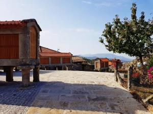 洛维奥斯CASA DO SANTO的一座有树的建筑和一些建筑的庭院